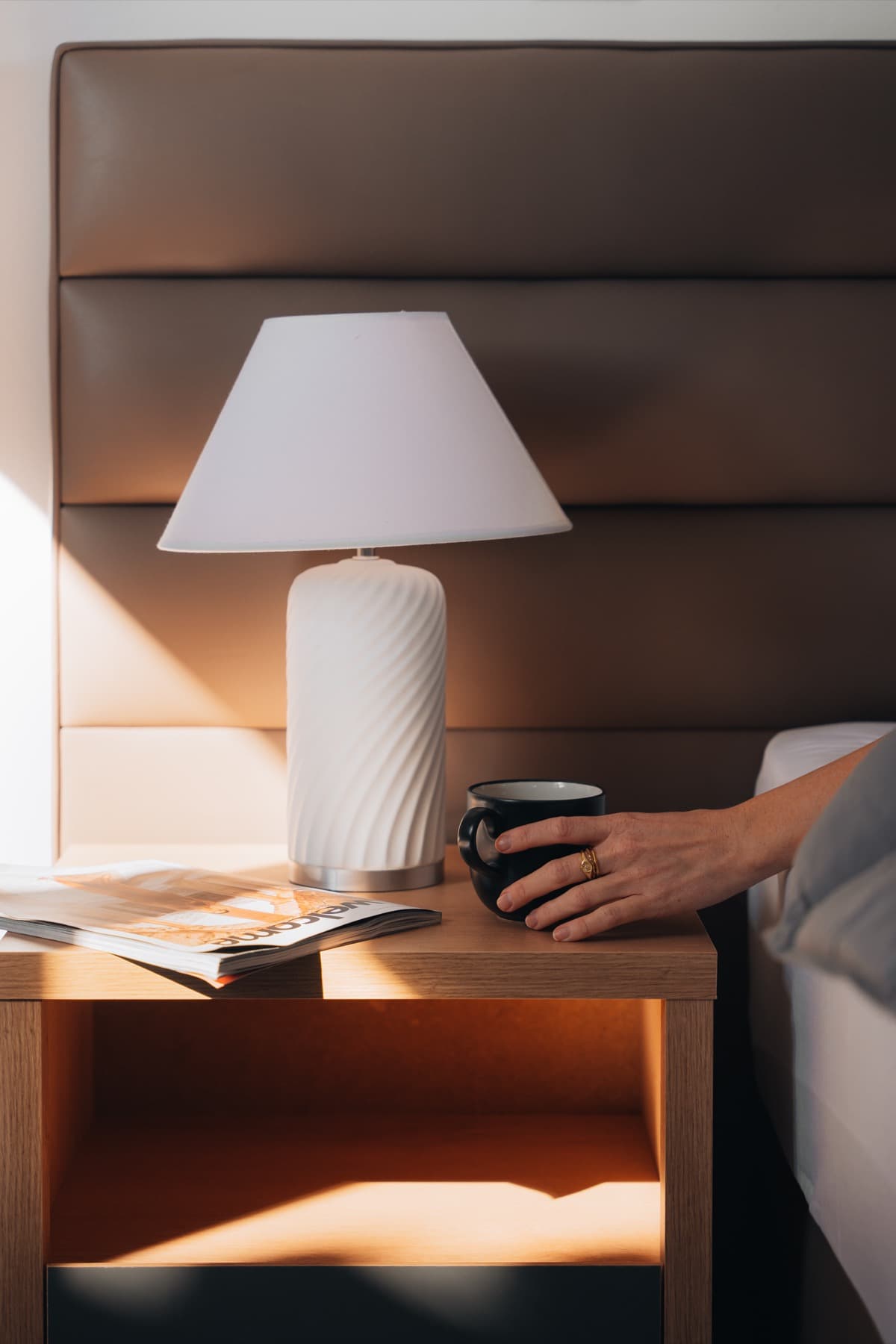 Morning coffee beside a sunlit bedside table