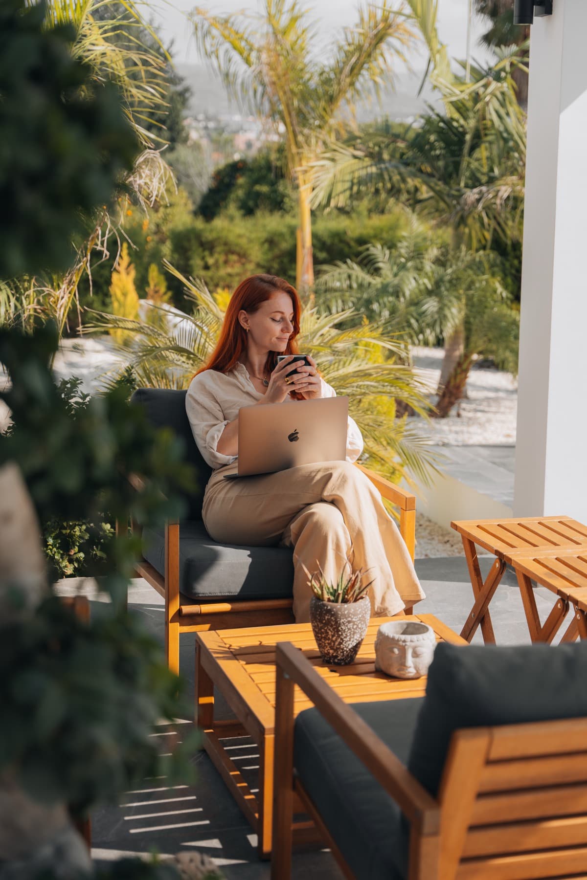 Guest working remotely from a villa terrace surrounded by greenery
