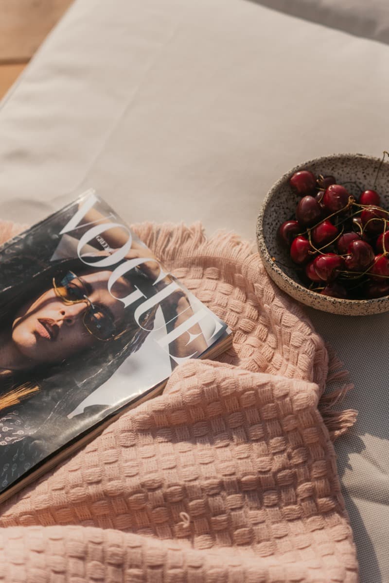 Luxury villa detail — Vogue magazine and fresh cherries on linen